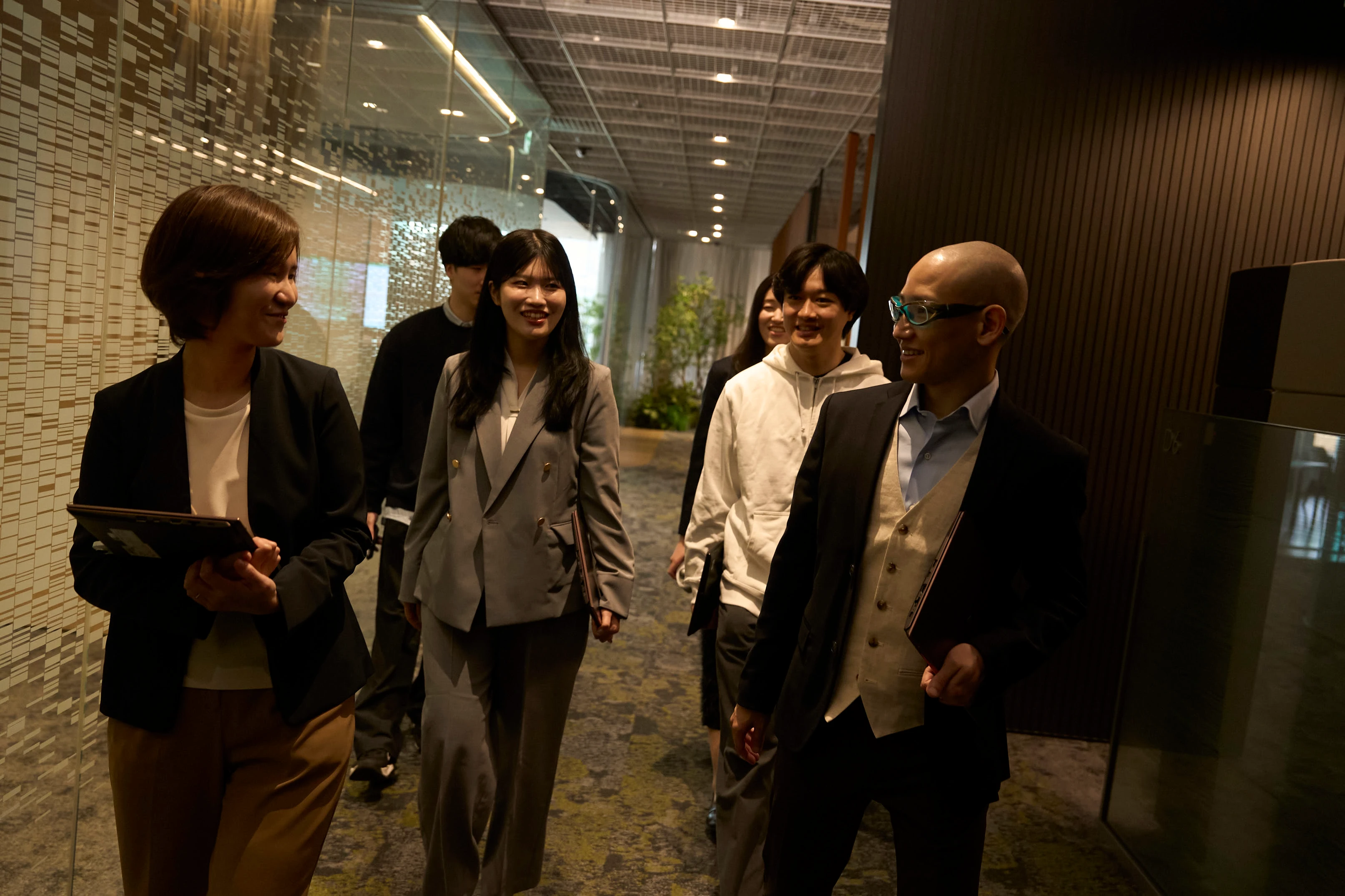 Image 2: MUFG team members walking together in an office corridor.