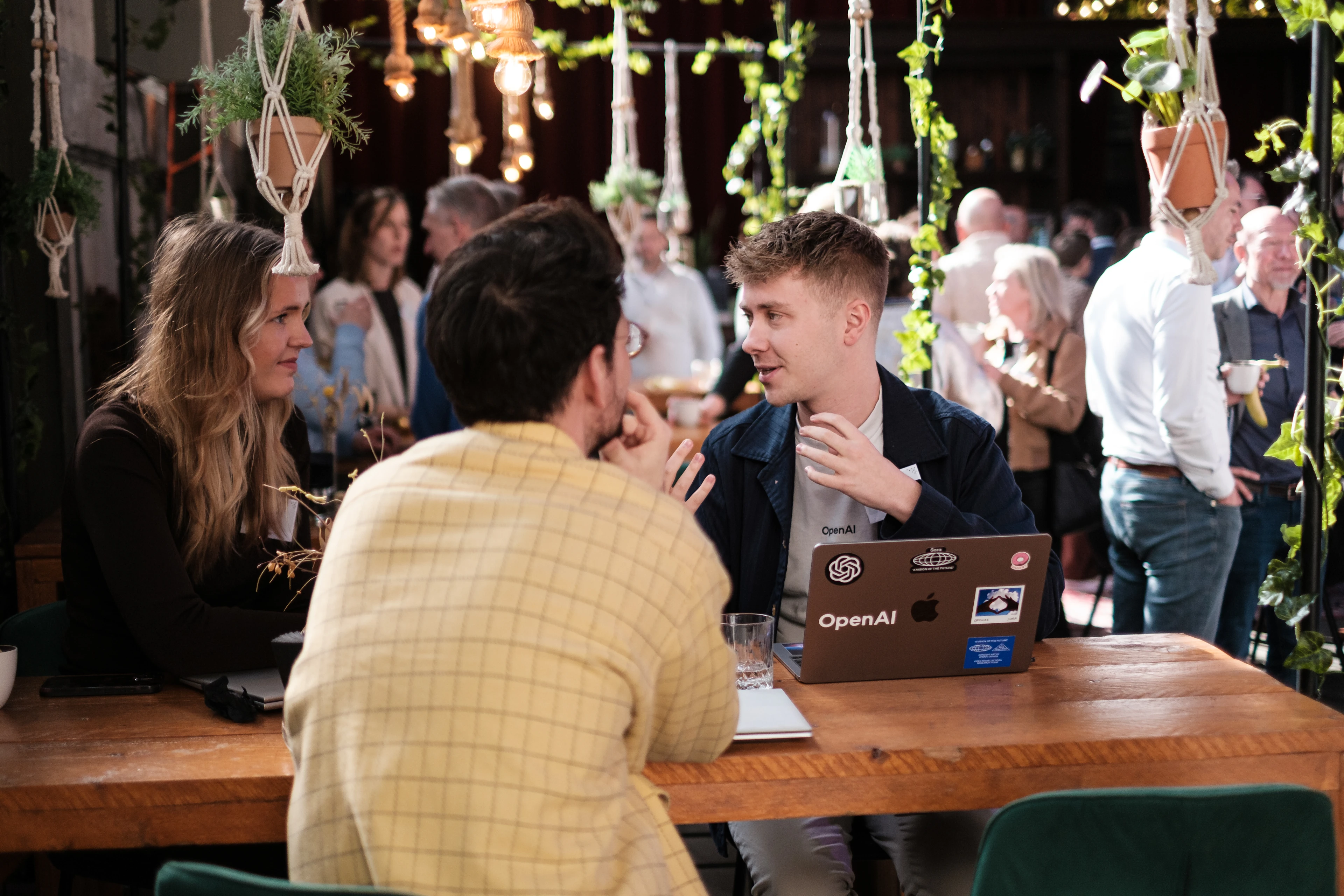 Image 1: People discuss AI around a table during a Univé leadership session.